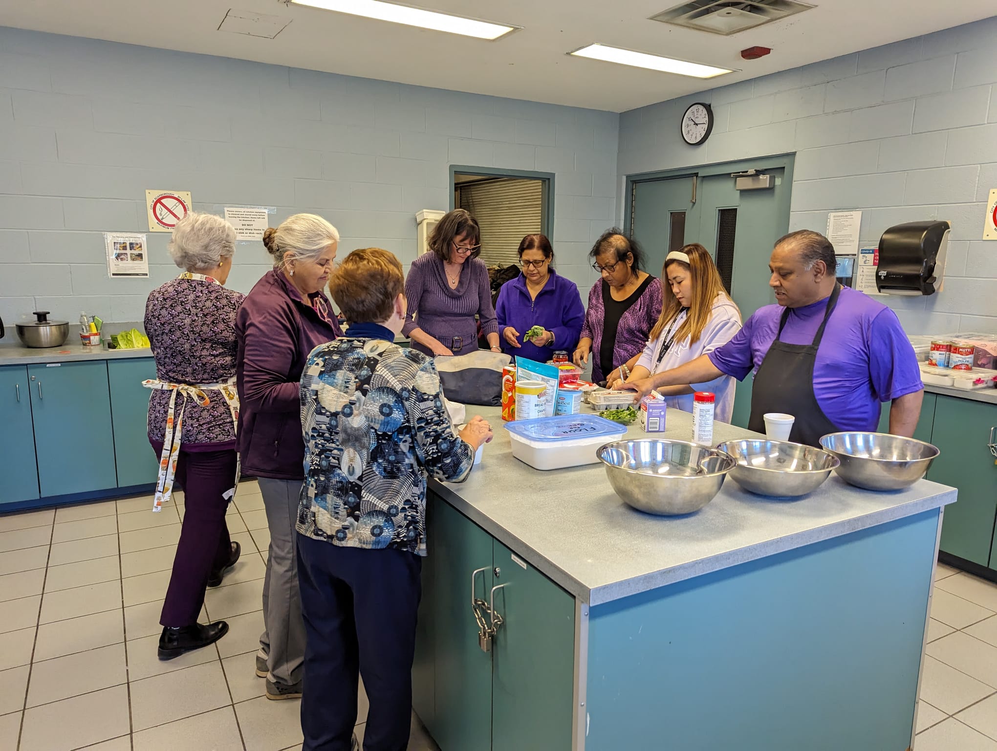 Community members participating in a group cooking program at Birchmount Bluffs Neighbourhood Centre.