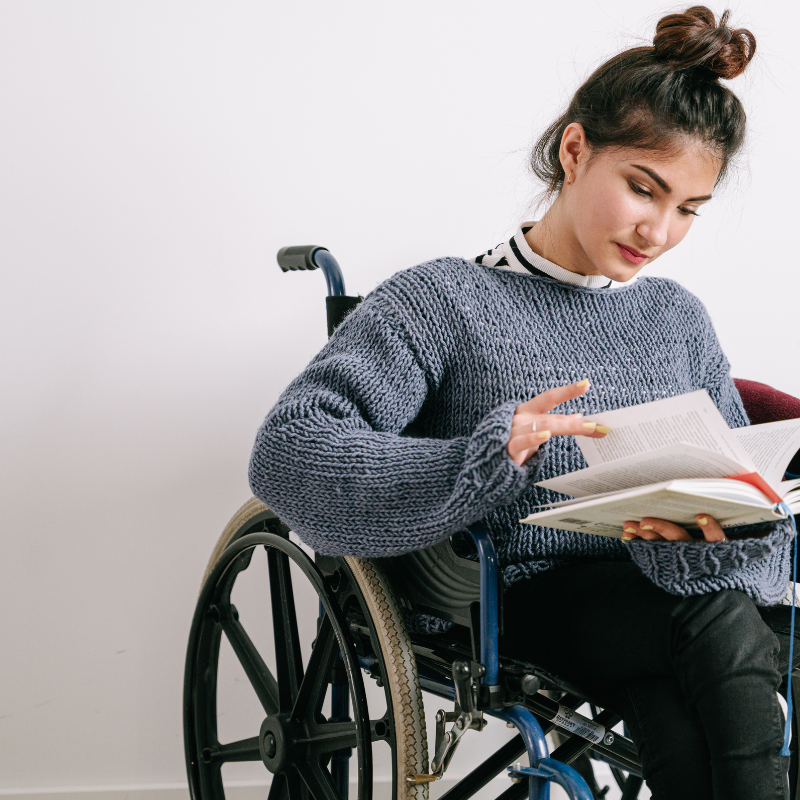Person using a wheelchair while reading and participating in an Active and Able program at BBNC